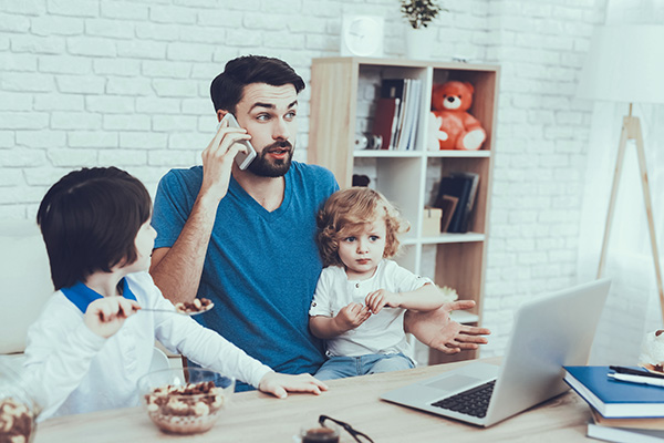 man working from home with children